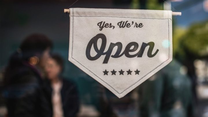 Image of a storefront at a grand opening, needing a website to attract customers.